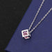 Cube pendant with pink diamond on a cross chain